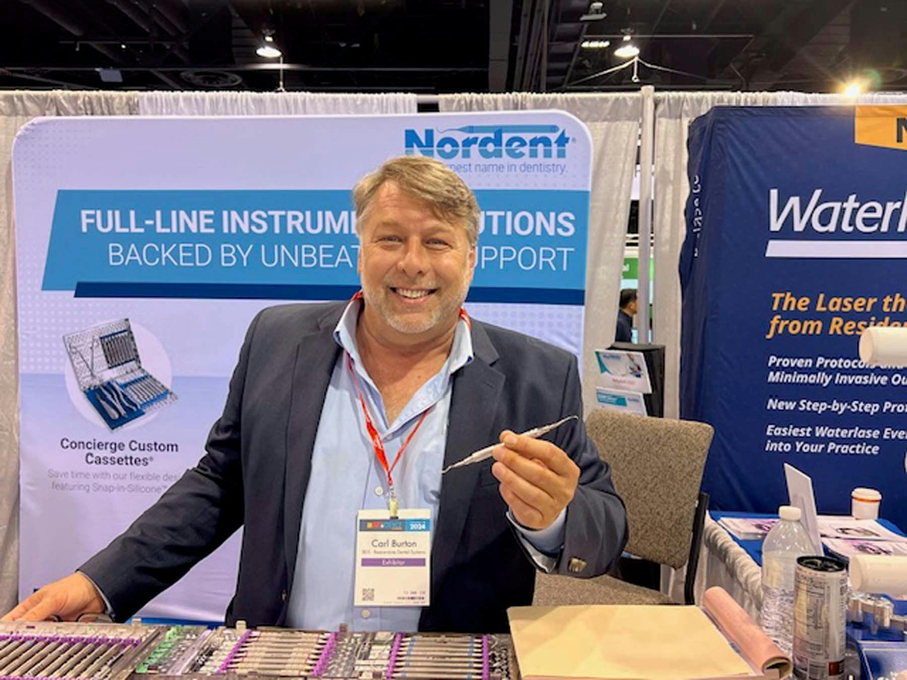 Carl Burton shows off a new line of Hartzell dental instruments at the Nordent Instruments booth on Thursday. | Image Credit: © Stan Goff
