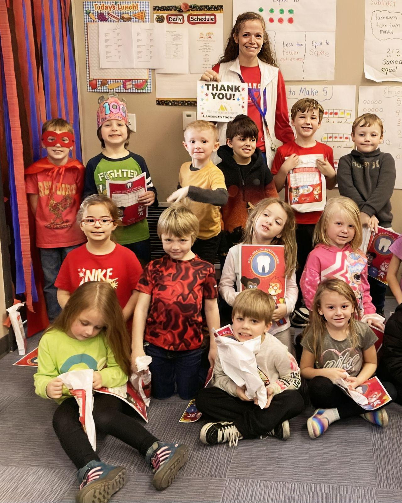 Ashley Conder, a school nurse at Midland School District in Pleasant Plains, Arkansas, poses with her young students and oral health education kits provided by America’s ToothFairy through their Smile Guardian Program. | Image Credit: © America's ToothFairy